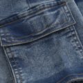 Nahaufnahme einer blauen Jeans mit einer aufgesetzten Tasche und brauner Kontrastnaht, modernes Textildesign.