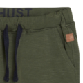 Grüne Jogginghose mit blauem Kordelzug und Tasche mit Lederetikett, Detailansicht oben.