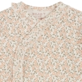 Babybody mit zartem Blumenmuster in Rosa und Grün auf cremefarbenem Hintergrund, mit Rüschenumrandung und Druckknöpfen.