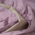 Innenseite einer rosa Jacke mit elastischem Bund, Nahaufnahme der Nähte und Textur des Stoffs für Modedetail.